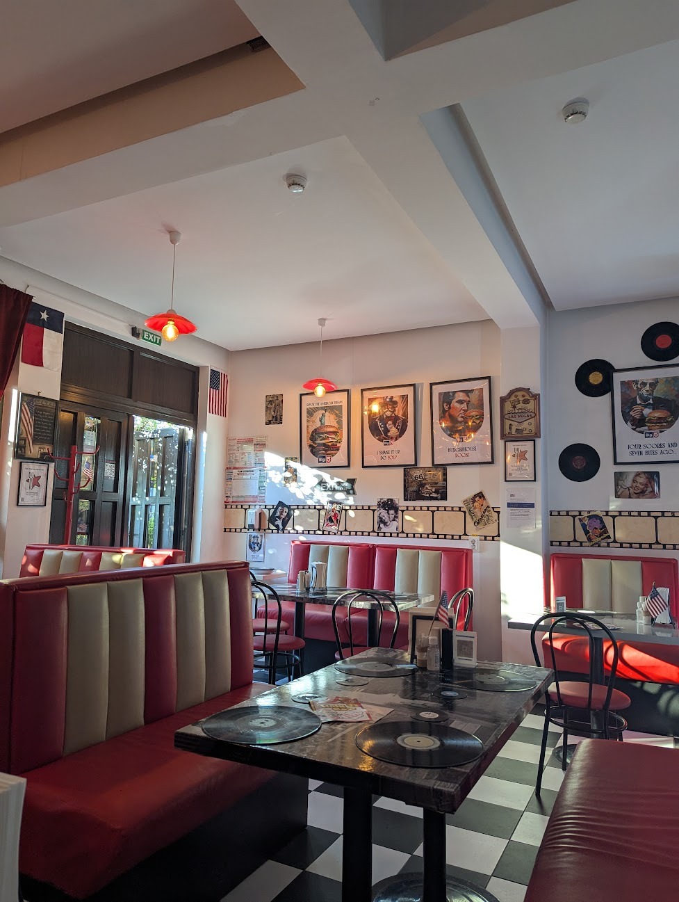Interiorul restaurantului Big5 cu decor retro american, separee din piele roșie, podea în carouri și postere vintage